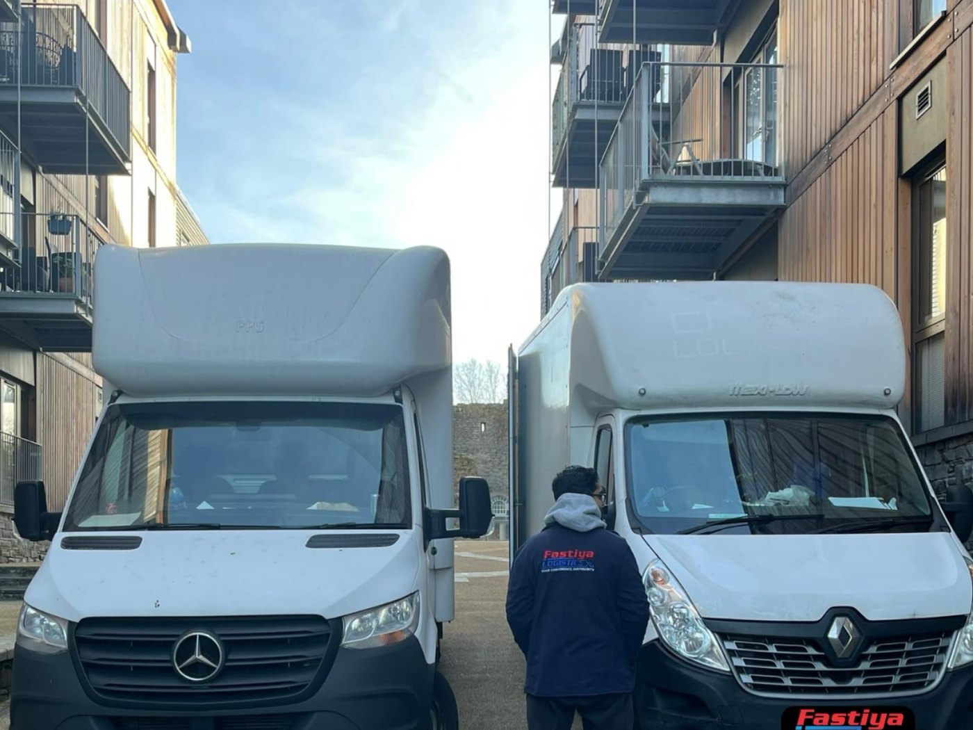 Two branded Fastiya Logistics Luton vans with a crew member between them