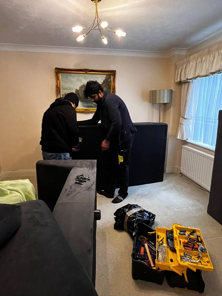 Two Fastiya Logistics movers assembling a sofa bed