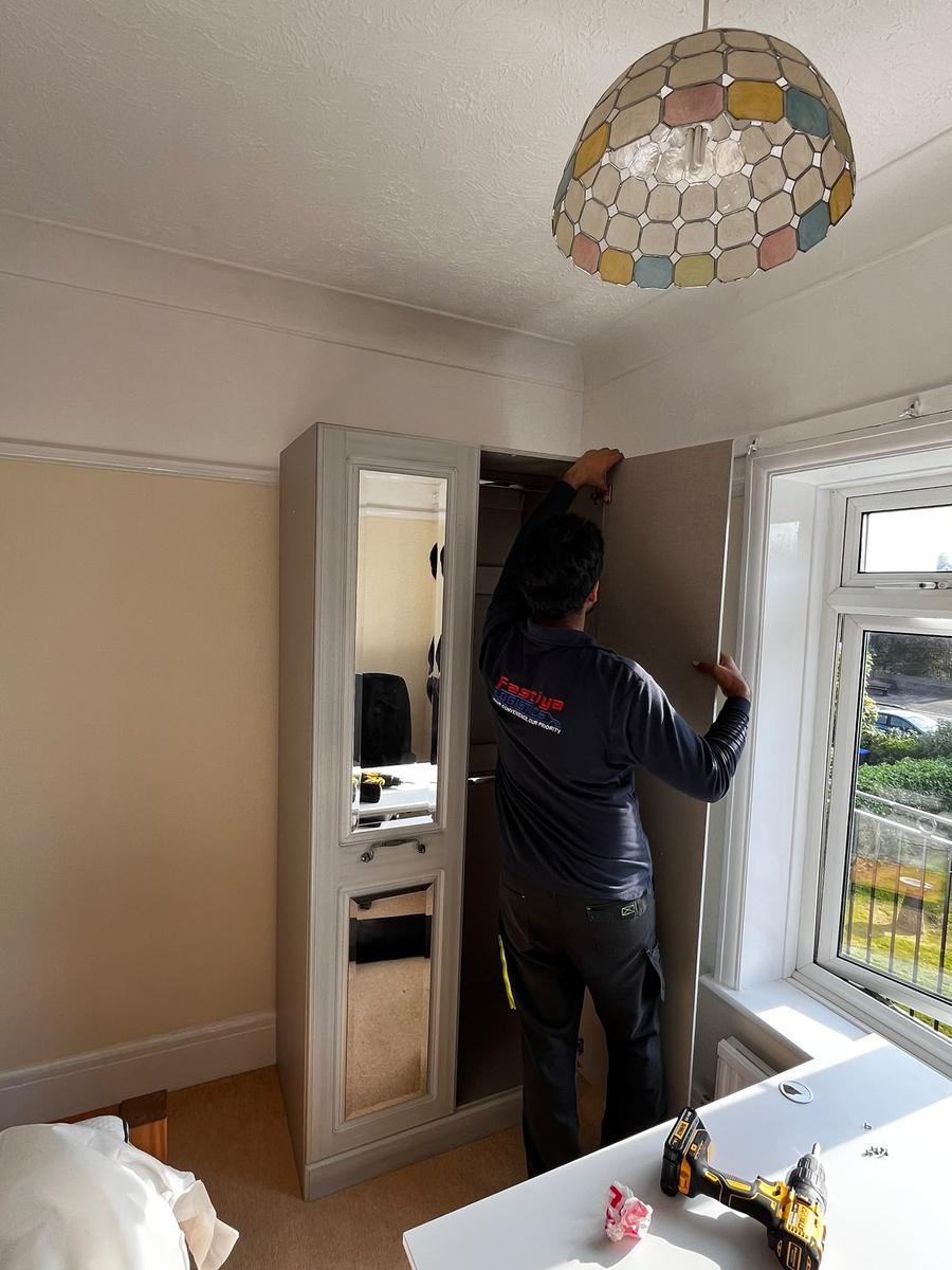 A Fastiya Logistics mover assembling a wardrobe in a customer's bedroom