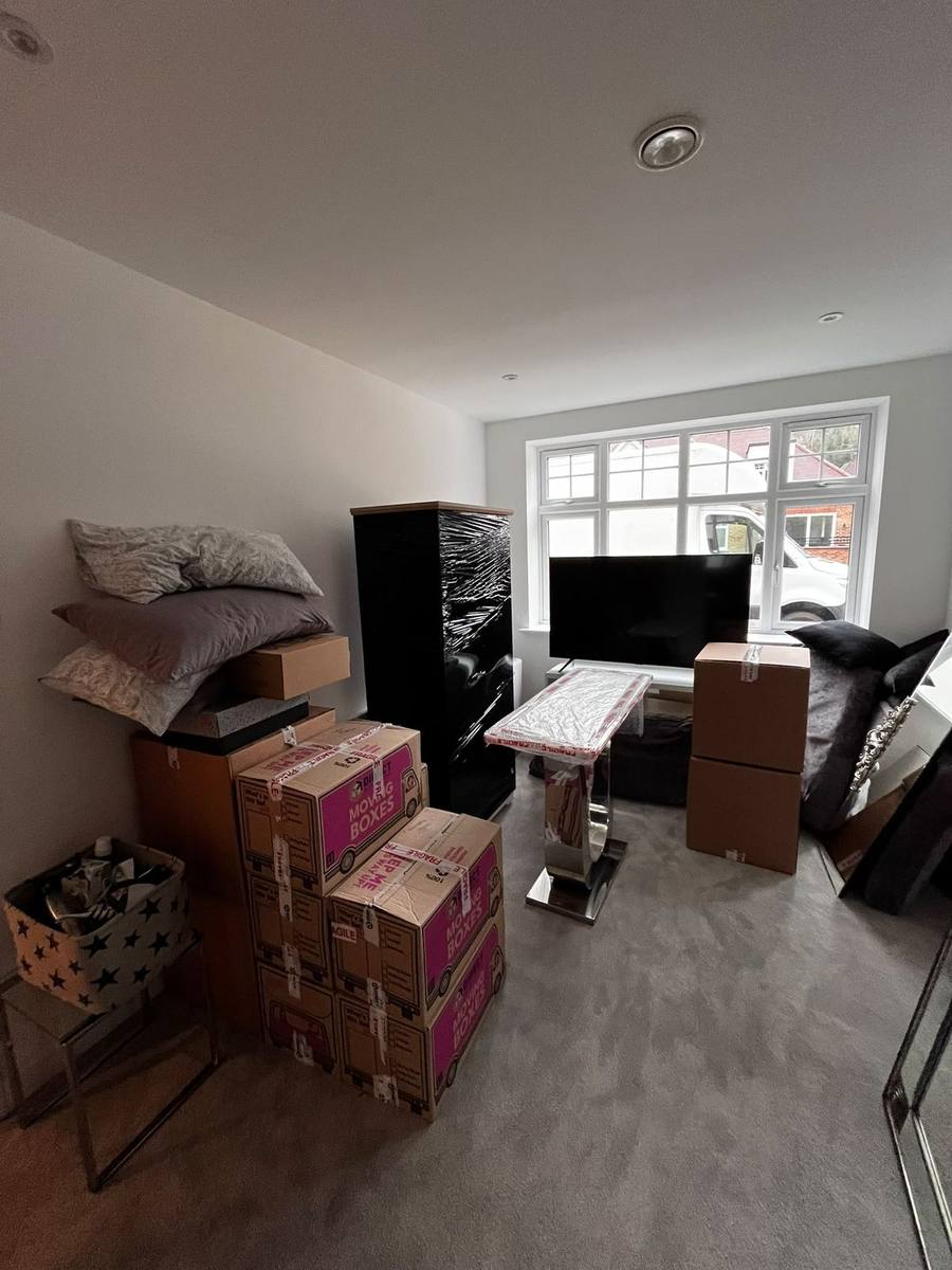 Labelled boxes and crates staged in a stairwell during a London move