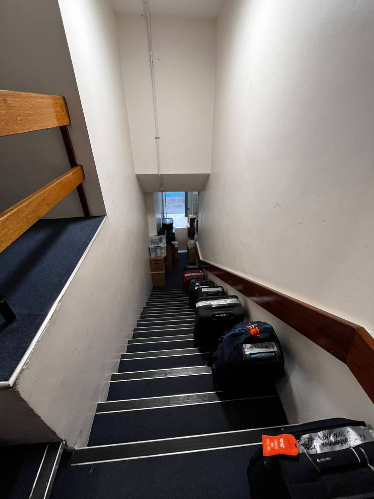 Cases and boxes staged down a stairwell ready to load