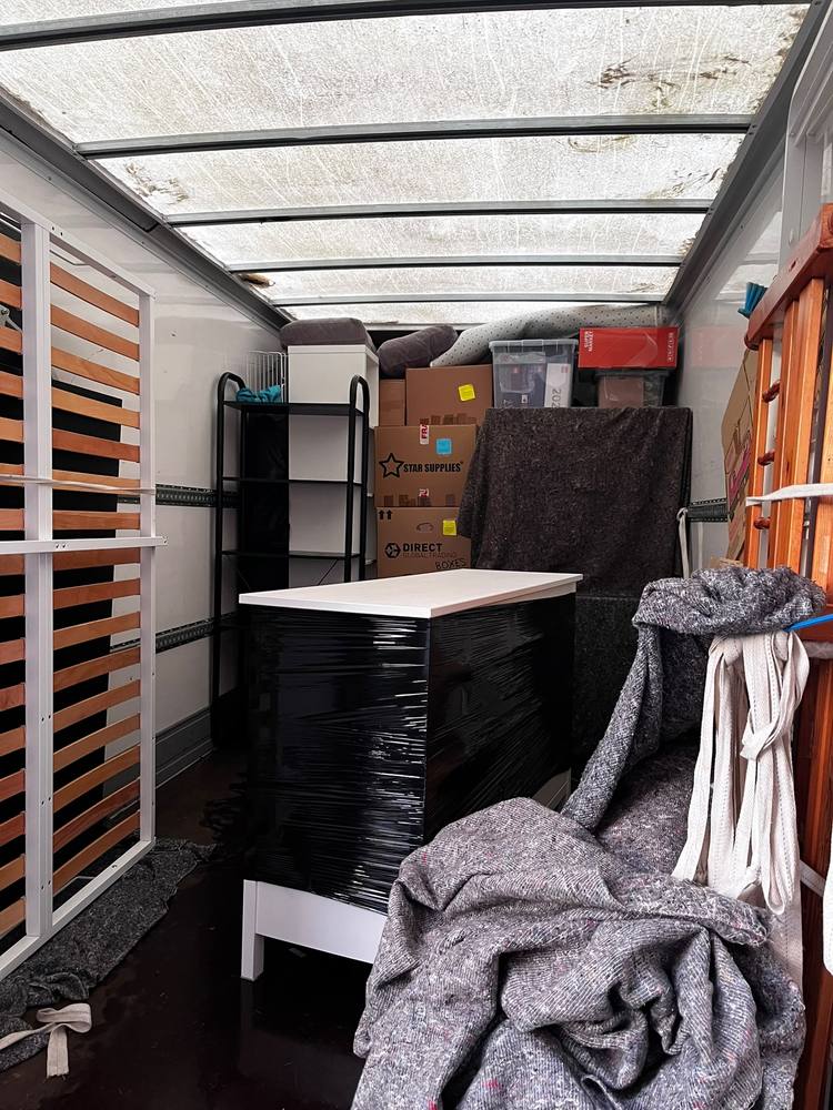 A Fastiya Logistics van loaded with wrapped furniture and labelled boxes