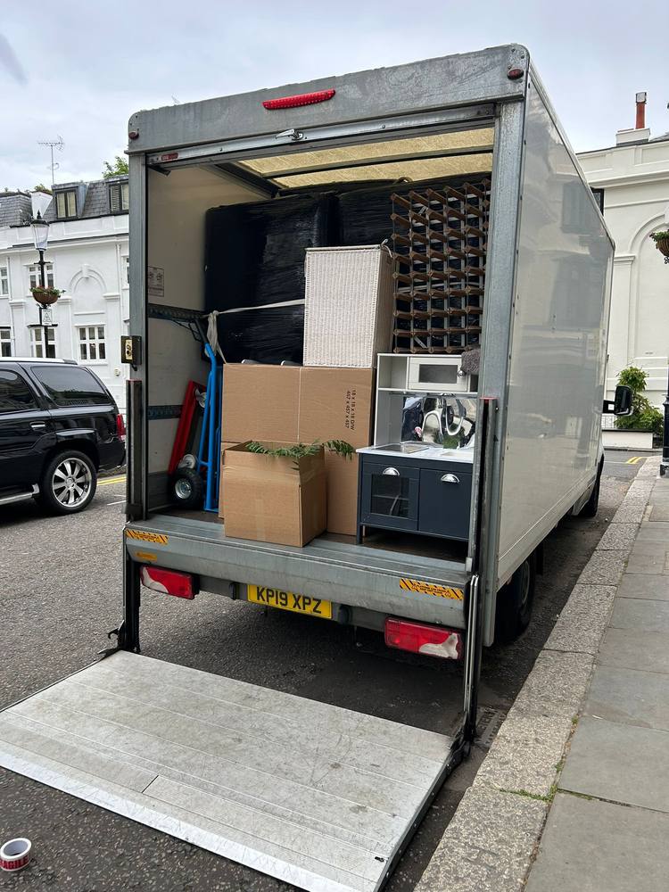 A loaded Fastiya Logistics van with its tail lift down on a London street