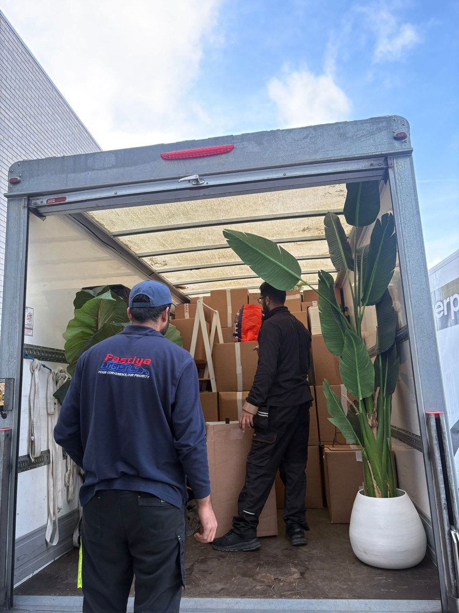Two Fastiya Logistics movers loading boxes and plants into a Luton van