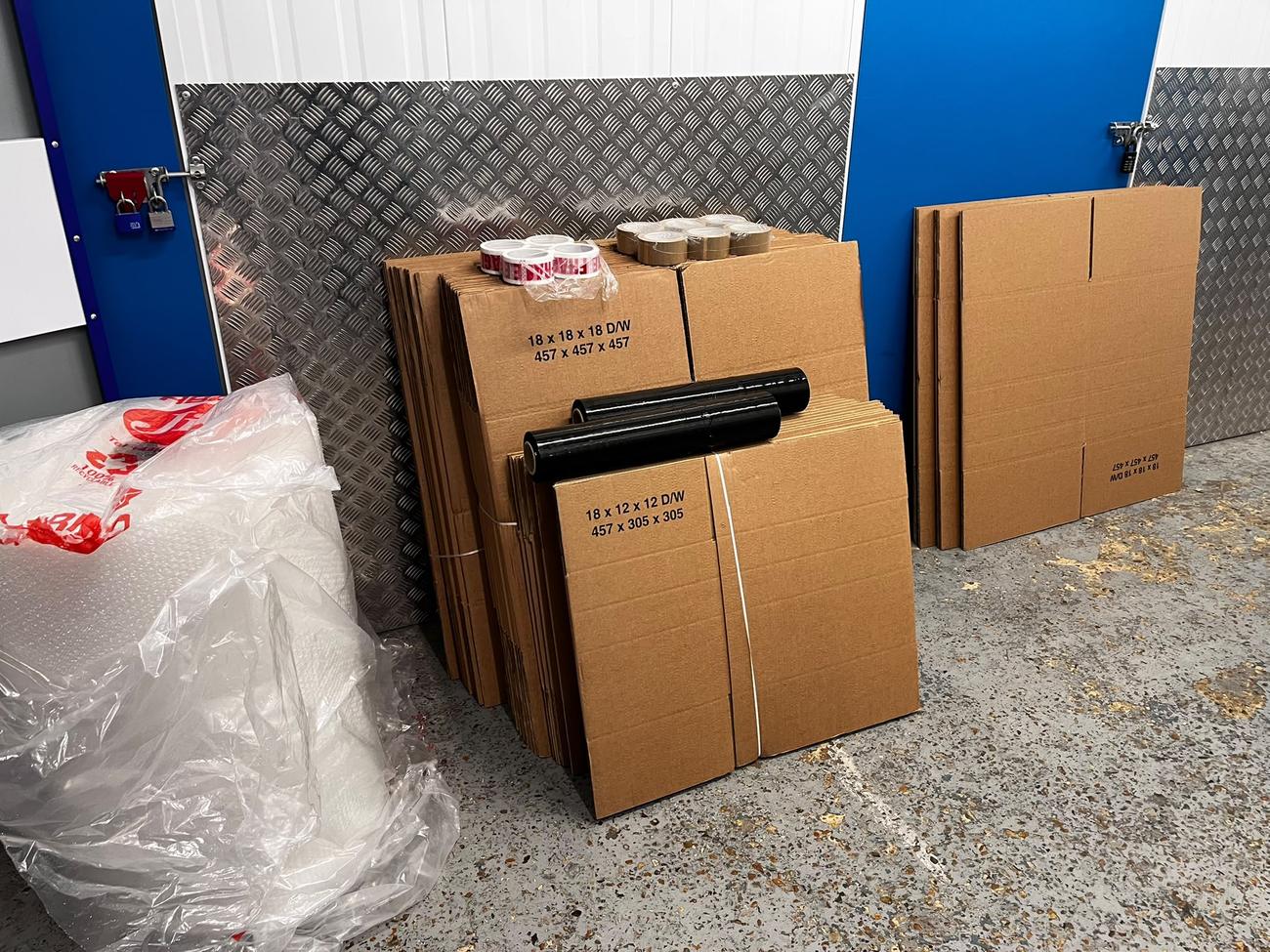 Stacks of double-walled moving boxes, packing tape and stretch film