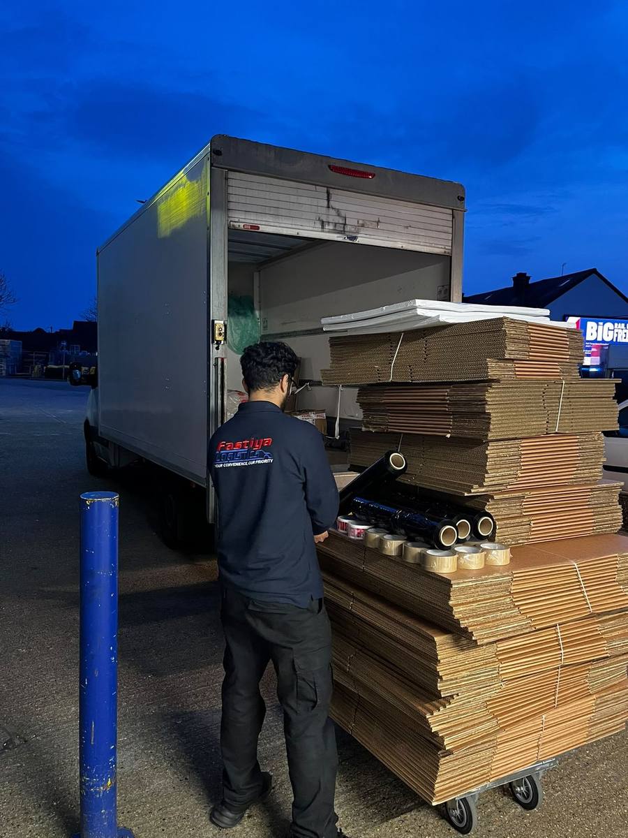Flat-packed boxes being loaded into the van for delivery