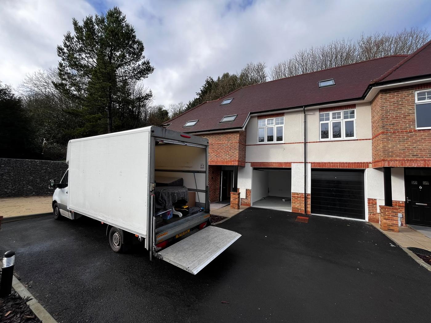 A Fastiya Logistics van with its tail lift down on a driveway