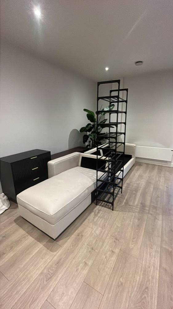 A corner sofa carried in and set down in a new living room